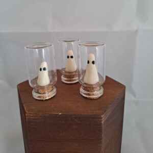 Tiny hand made ghosts inside corked jars.